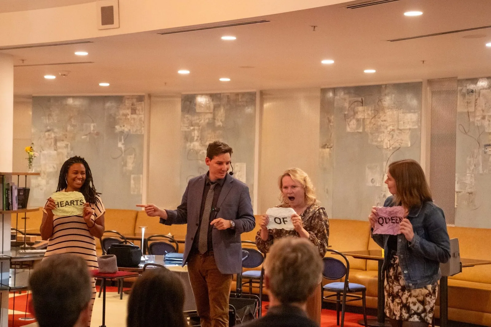 Michael Bloemeke performing a mentalism routine on stage with three audience volunteers.