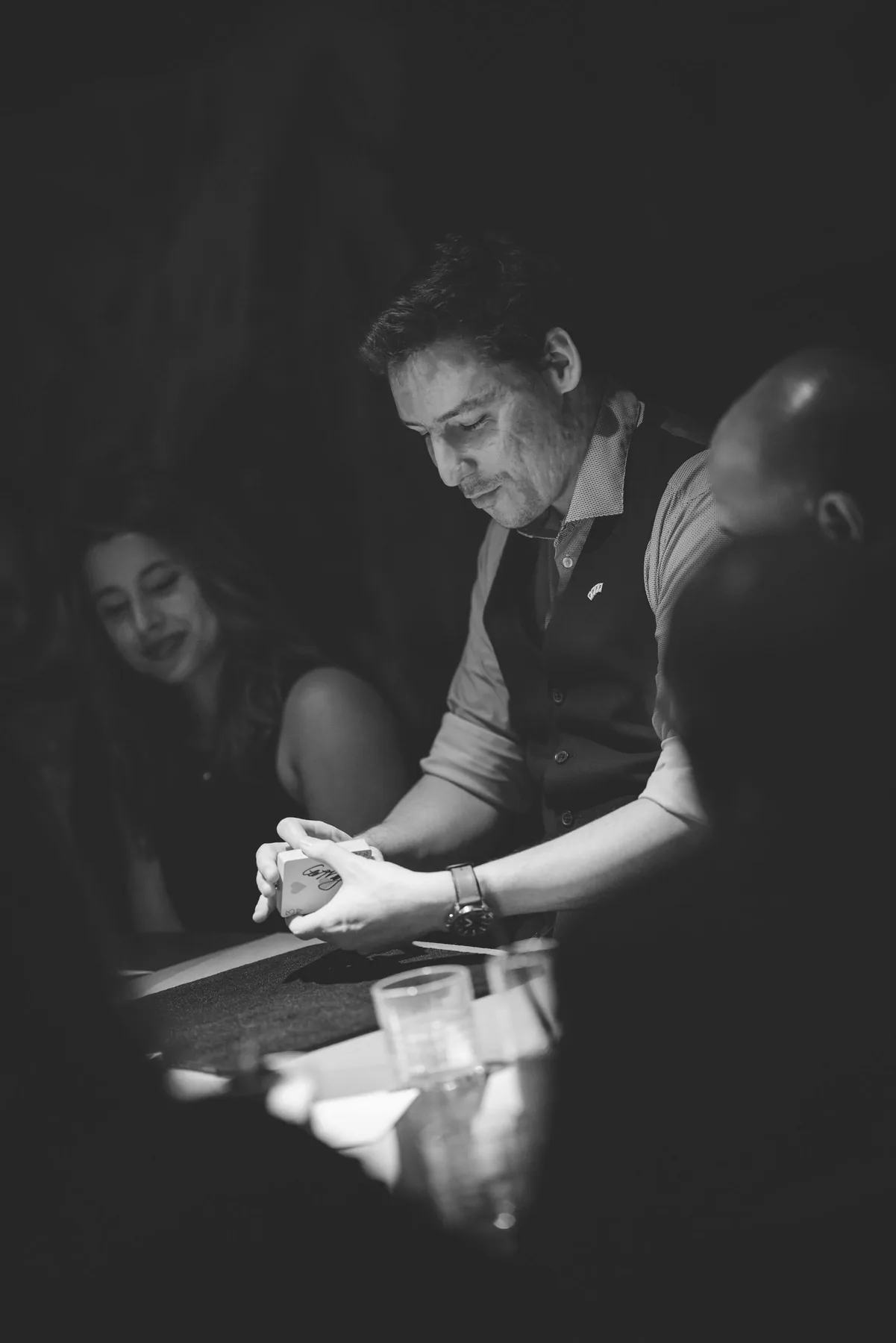 Michael Bloemeke performing card magic at a dimly-lit close-up table.